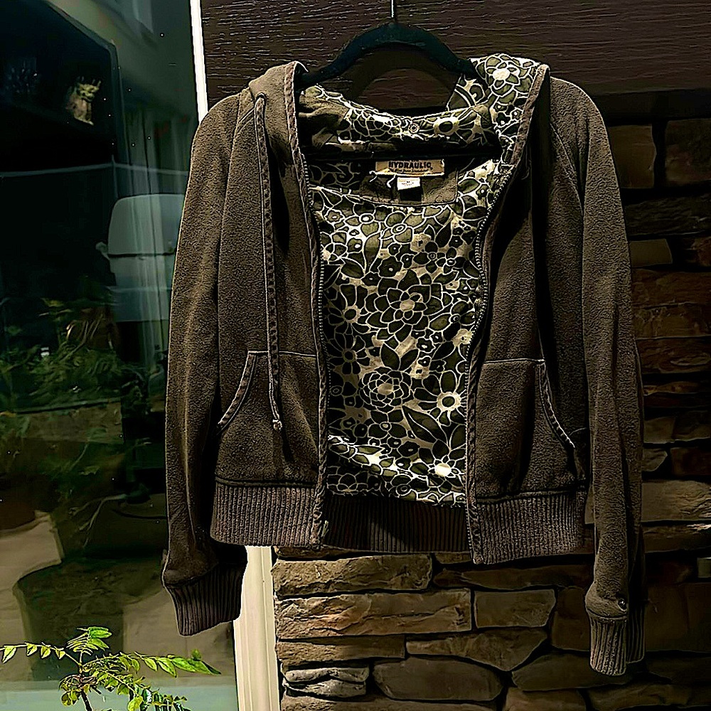 A zip-up hoodie in size medium with a gray outside and flowery inside.